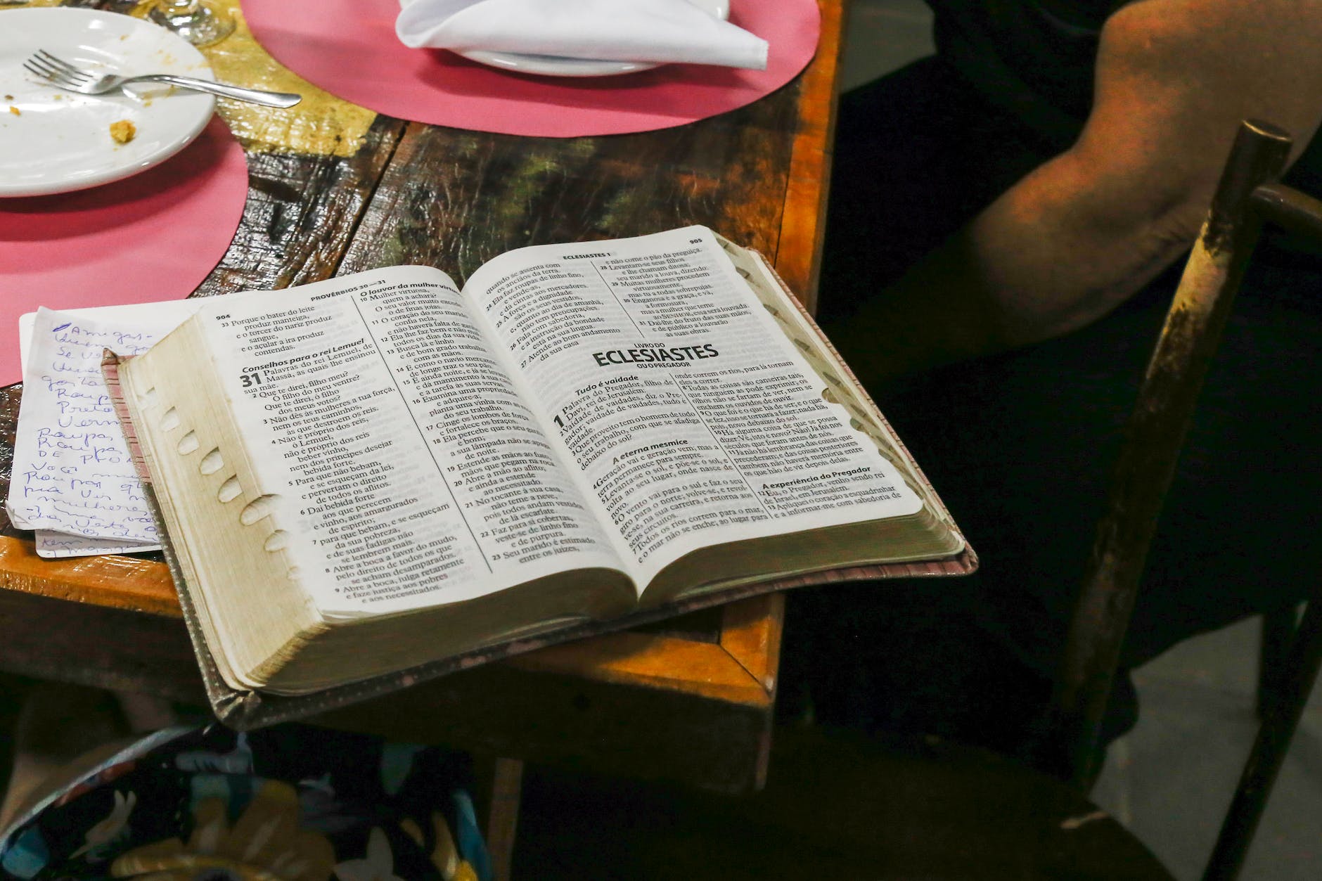 photo of opened bible book on brown table